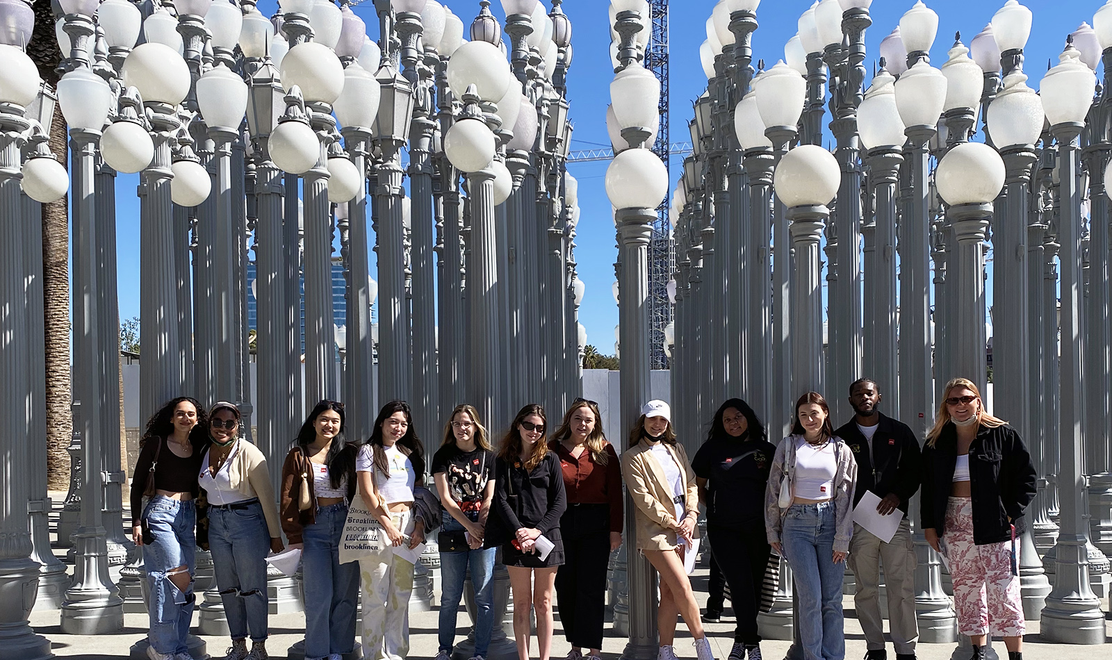 A group of students standing in front of many light posts
